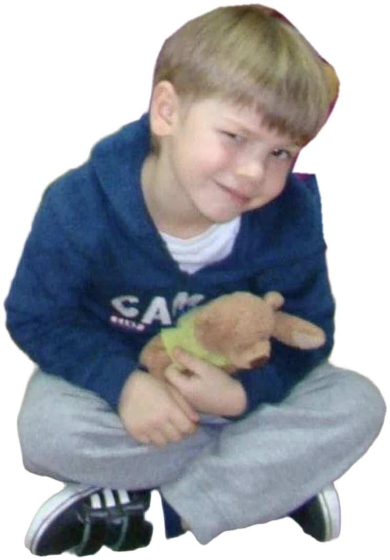 Danylo Kozak as a small boy, sitting cross-legged with a teddy bear